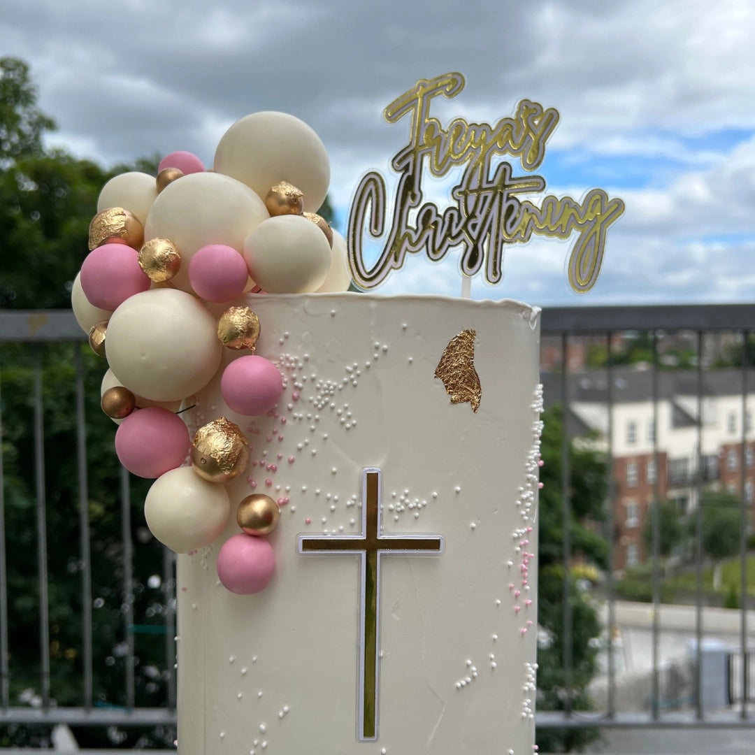 Cream and pink christening cake With gold cross