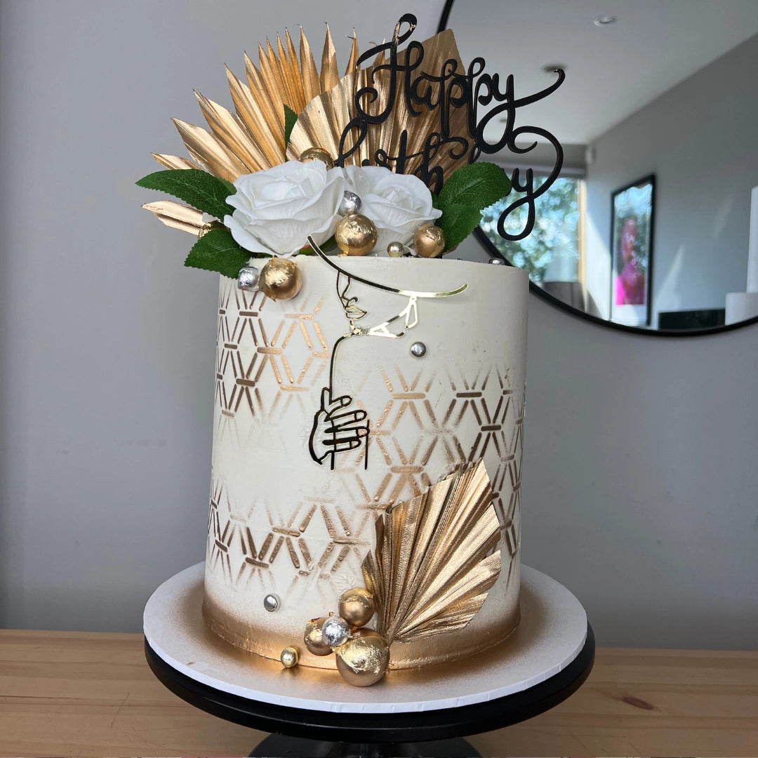 ELEGANT CREAM AND GOLD CAKE WITH PALM SPEARS AND FLOWERS