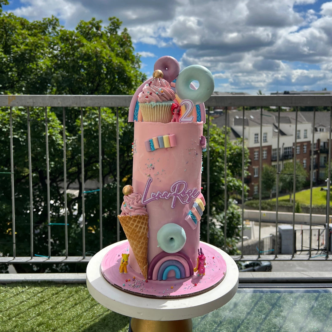 Extra tall Pink candy cake with rainbows