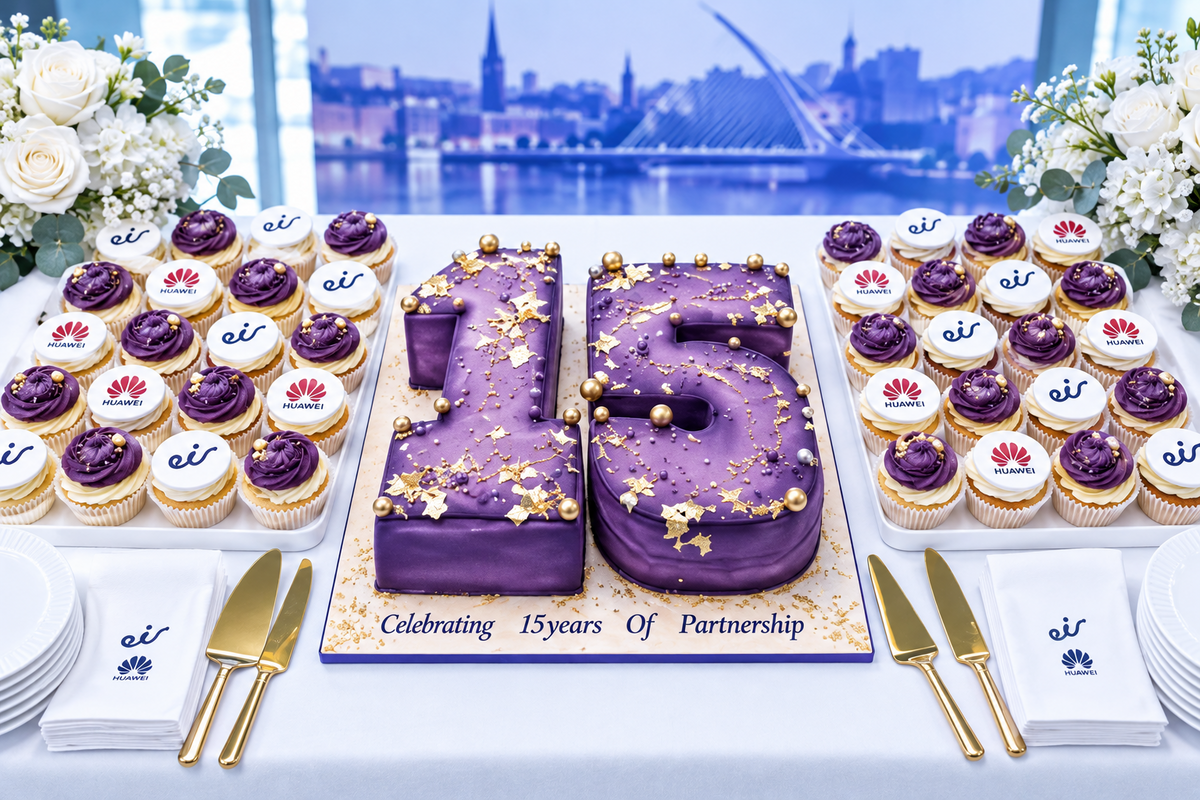 A catering table set up with two chocolate cakes, cupcakes, plates, and utensils in front of a large Huawei event backdrop reading 'Together, Empowering Ireland's Digital & Intelligent Future'.