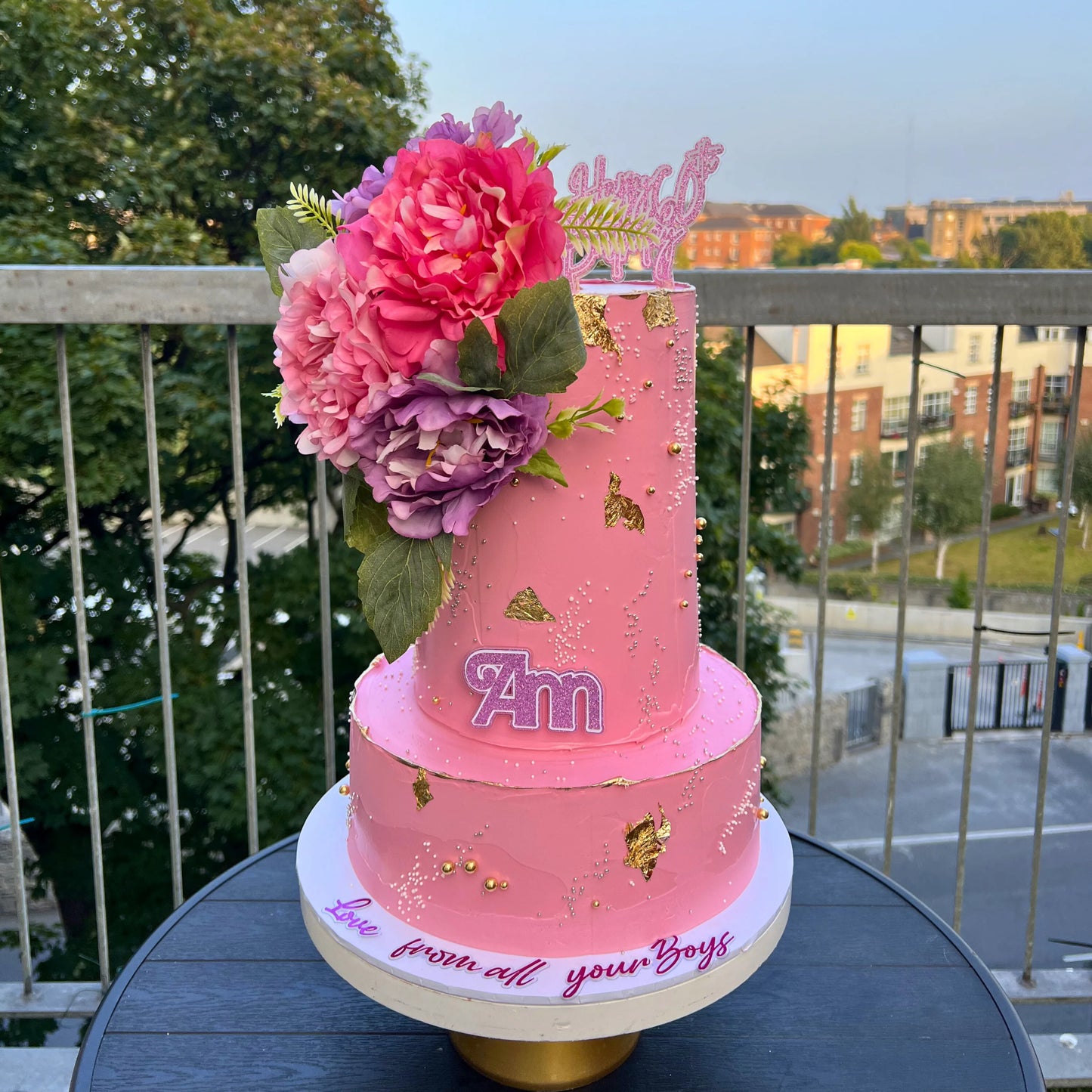 2 tiers Pink birthday cake with flowers on a balcony