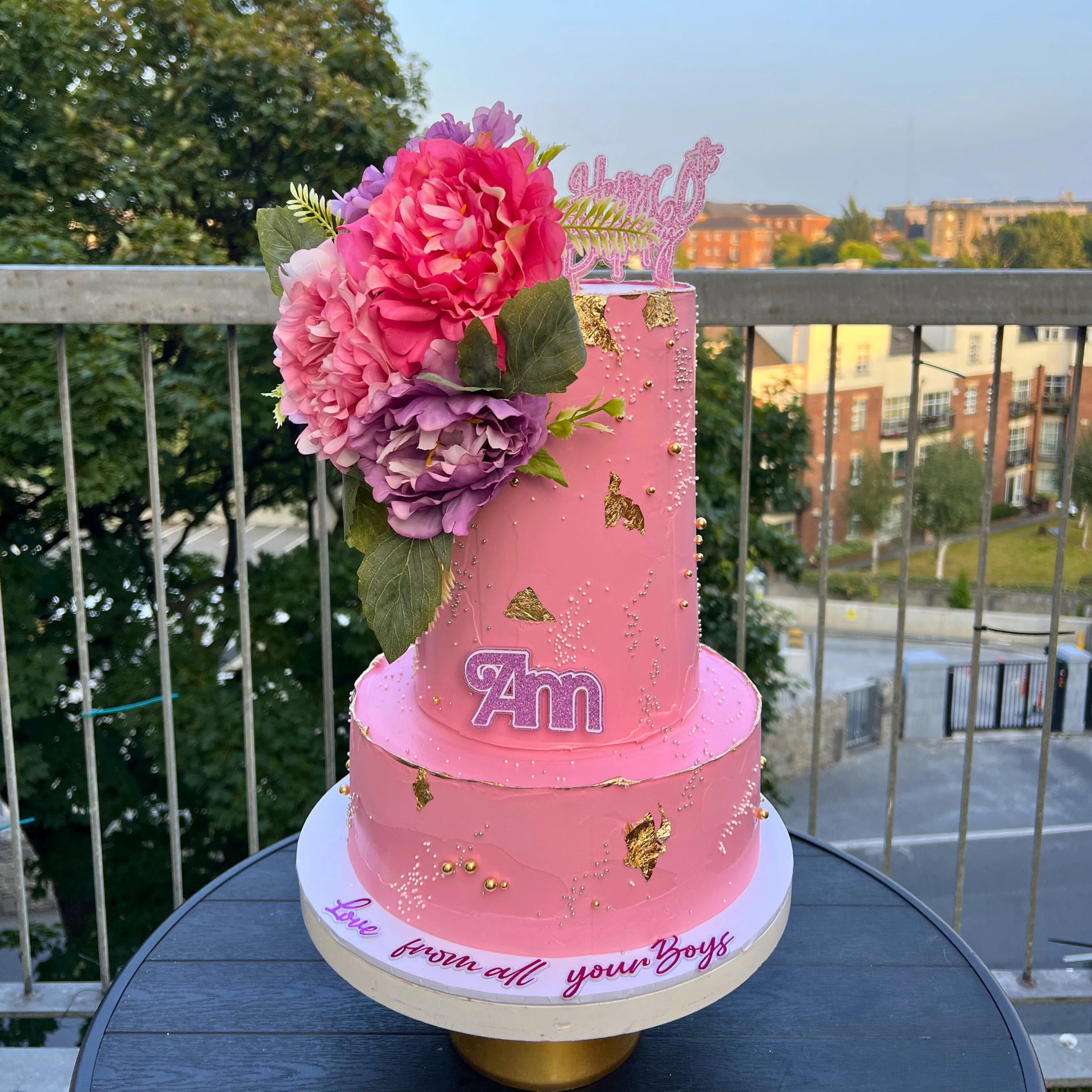 2 tiers Pink birthday cake with flowers on a balcony
