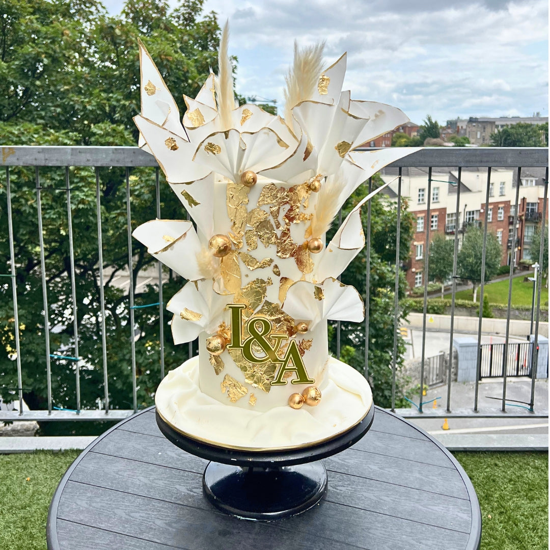 White and gold wafer paper wedding cake with sculptural sails, edible gold leaf and personalised monogram, handmade in Dublin by CakeMeAway