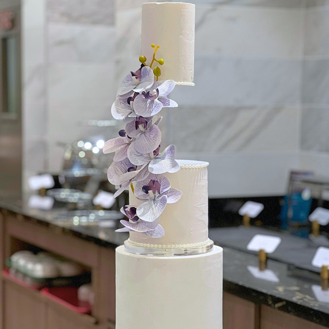 Close-up of lilac orchid cascade on a blush three tier floating wedding cake, CakeMeAway Dublin