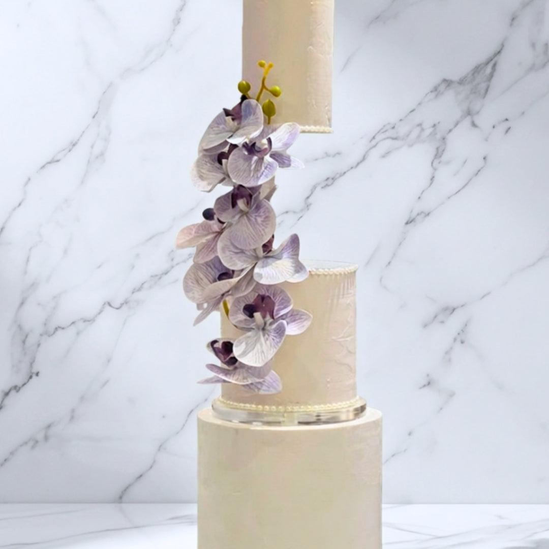 Blush floating wedding cake with pearl piping and cascading lilac orchids, Dublin