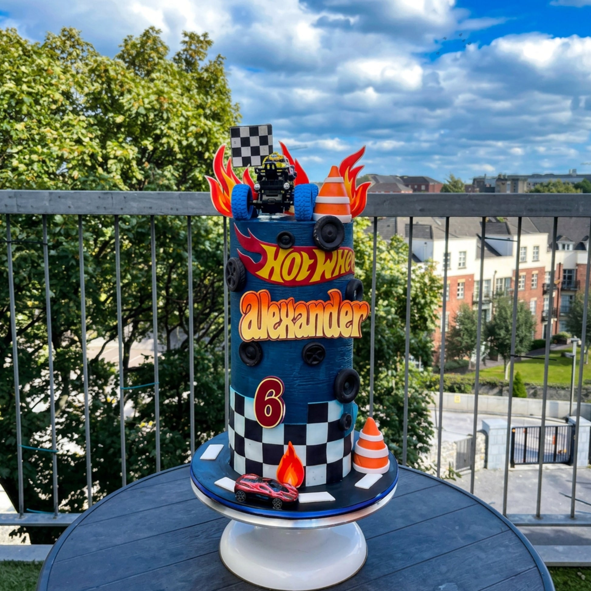 Tall racing themed cake with fondant flames, moulded tyres and personalised name, handmade in Dublin