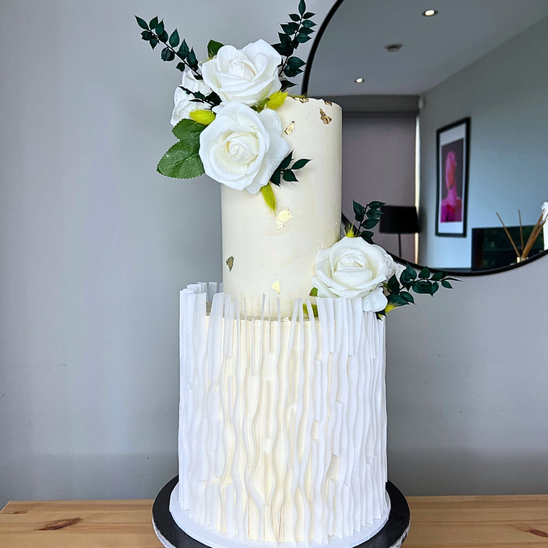 White two tier wedding cake with vertical texture, gold leaf and white rose arrangement, CakeMeAway Dublin