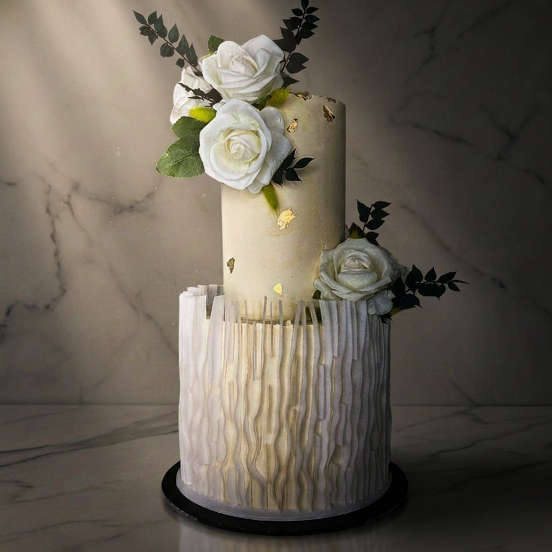 Textured two tier wedding cake with white roses and foliage displayed on a gold hoop stand, CakeMeAway Dublin