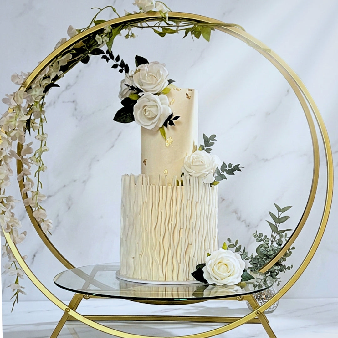Ivory textured wedding cake with gold leaf on a gold hoop stand with trailing florals, Dublin