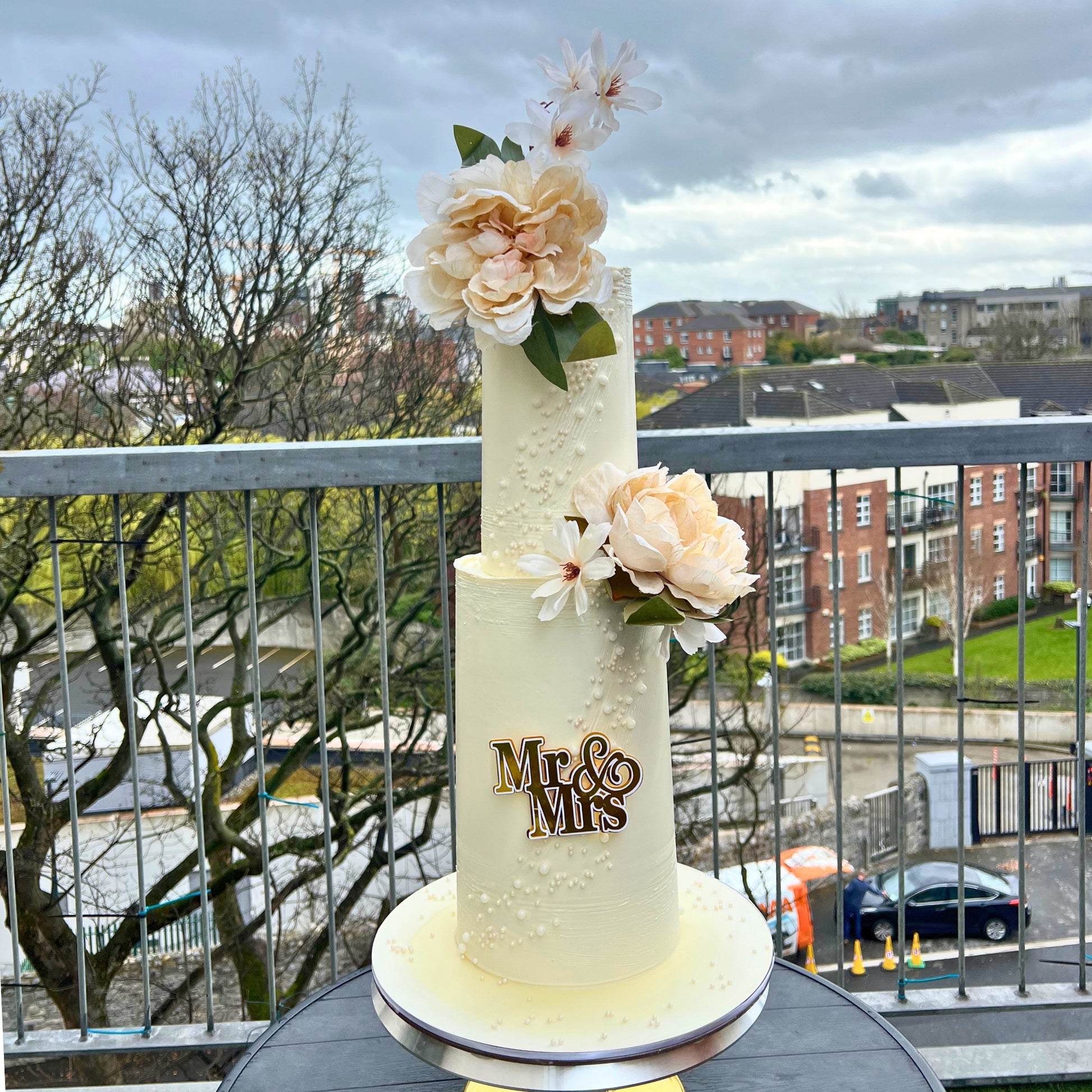 Small two tier wedding cake in ivory buttercream with trailing sugar pearls and blush peonies, Dublin