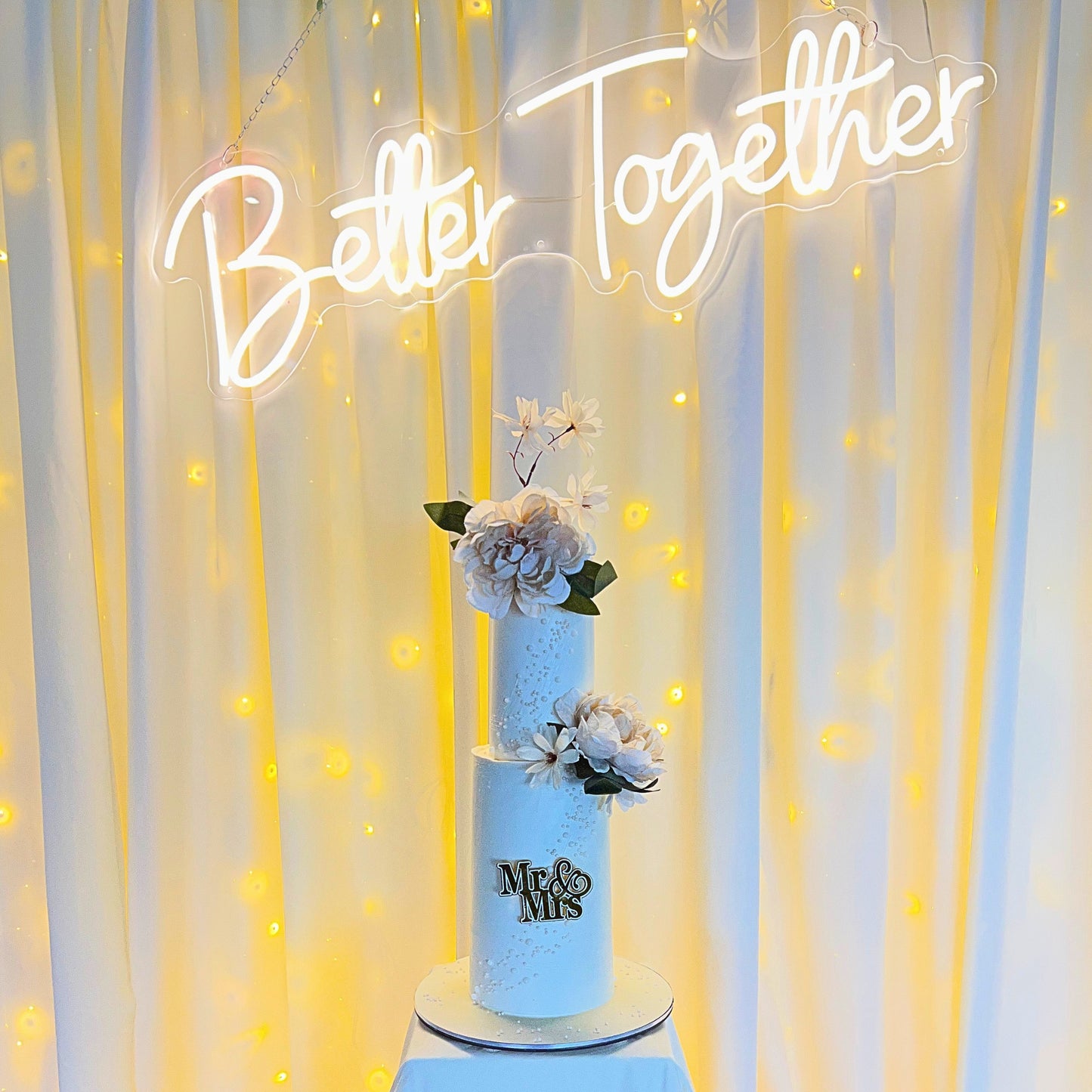 Intimate two tier wedding cake with sugar pearls beneath a Better Together neon sign, CakeMeAway Dublin