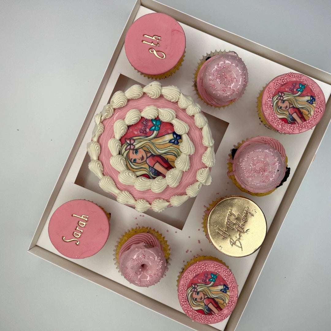 Close-up of a BARBIE themed bento cake with intricate buttercream piping and matching artisan cupcakes.