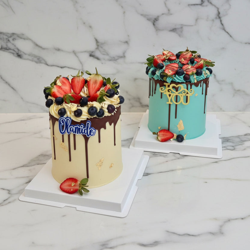 Two decorated cakes on a table with a garound