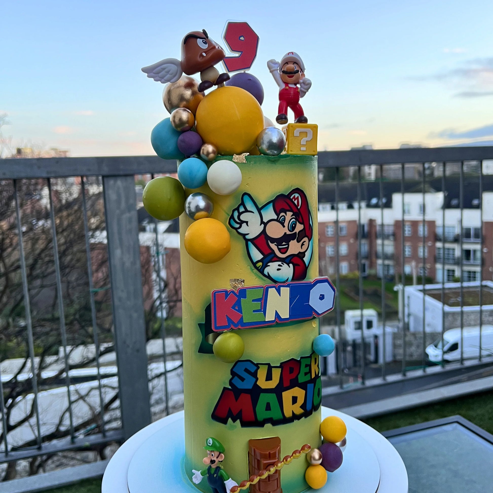 Colorful birthday cake with Super Mario theme on a balcony