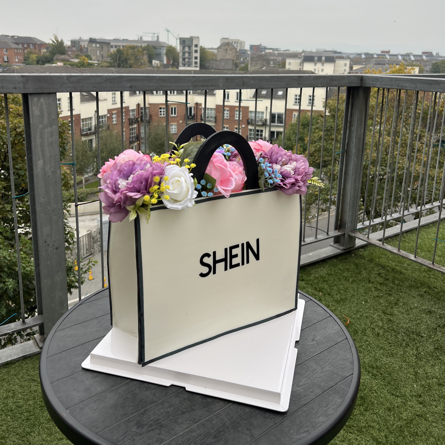 SHEIN shopping bag with flowers on a balcony