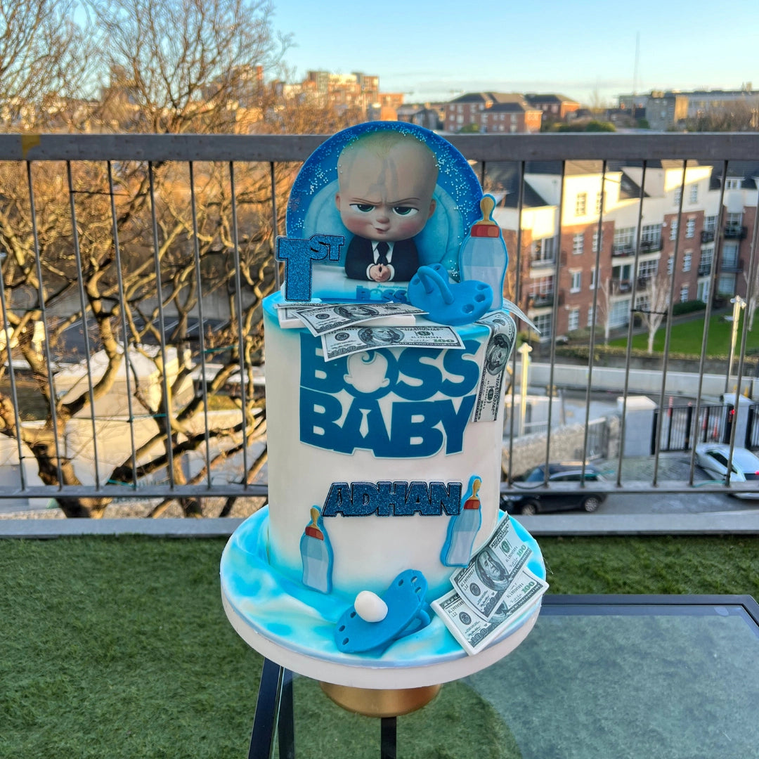 Tall luxury Boss Baby inspired birthday cake with hand-sculpted suit and tie details and premium blue buttercream, by CakeMeAway Dublin. with hand-sculpted suit and tie details and premium blue buttercream, by CakeMeAway Dublin.