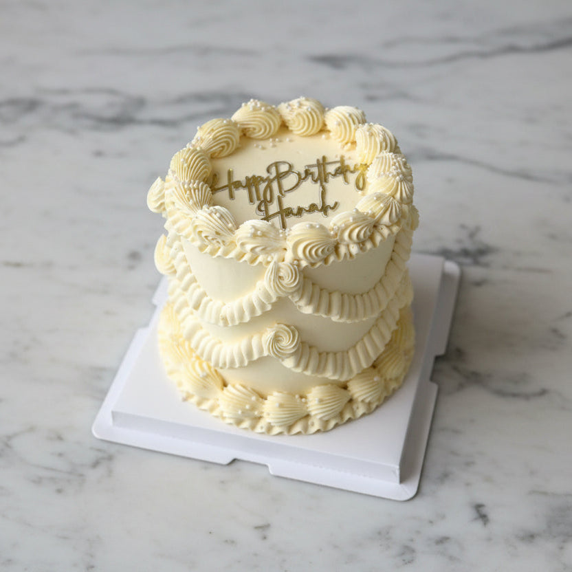 birthday cake with 'Happy Birthday Hannah' on a marble surface