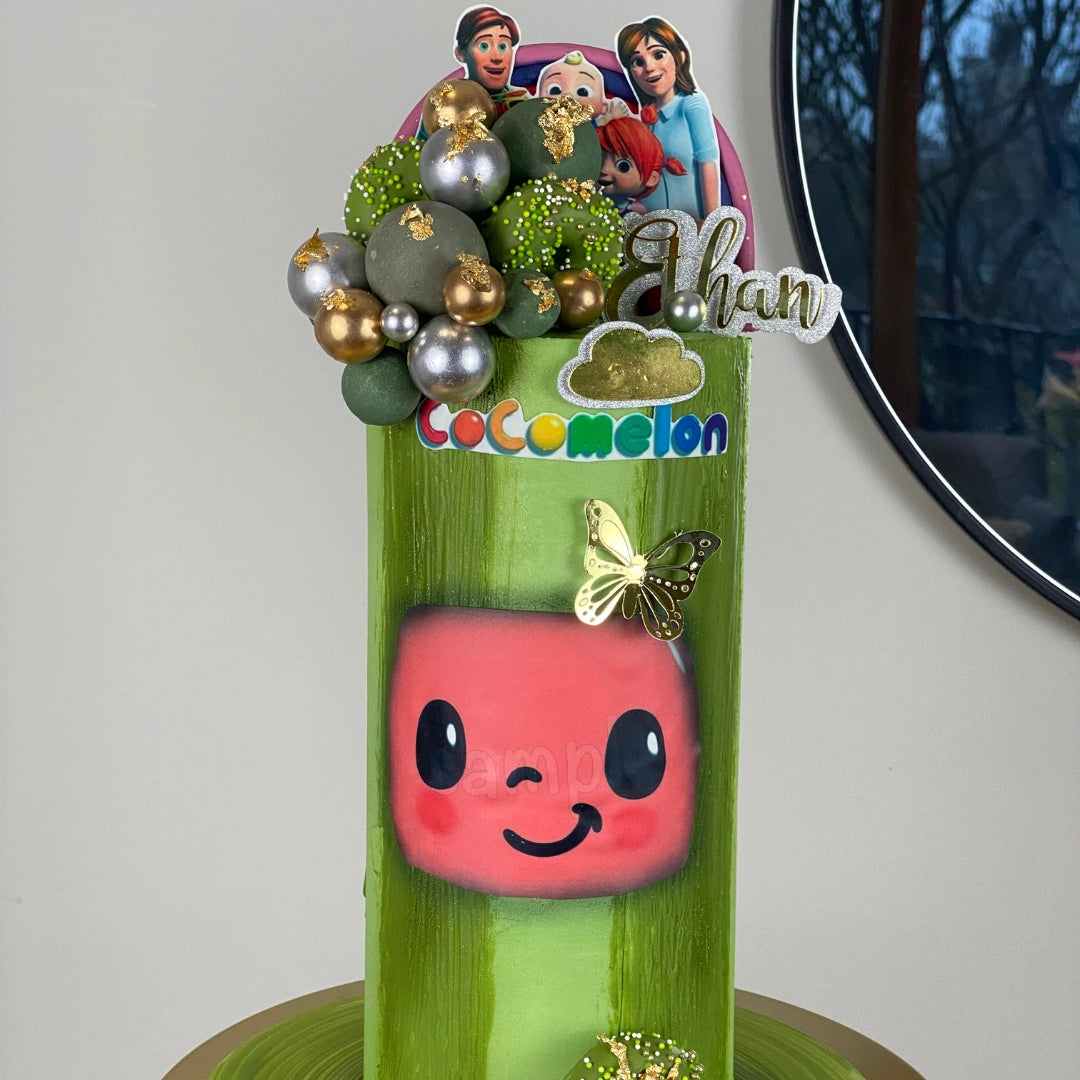 Close-up of a bespoke tall Cocomelon celebration cake featuring premium buttercream textures and gold-dusted details.