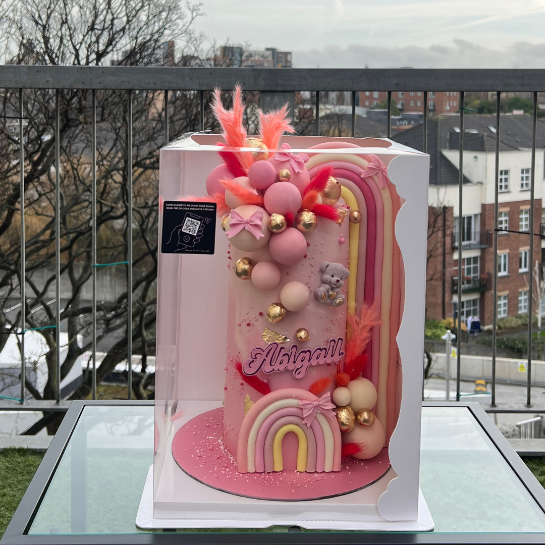 elaborate pastel pink cake with a giant rainbow