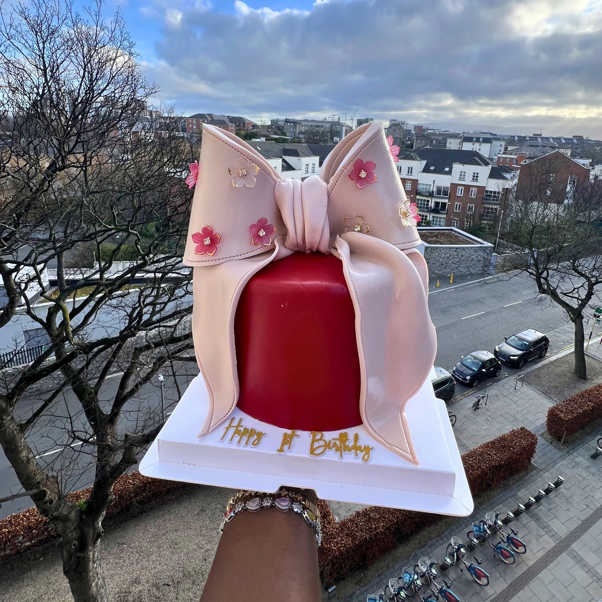 red fondant cake with a giant beige bow