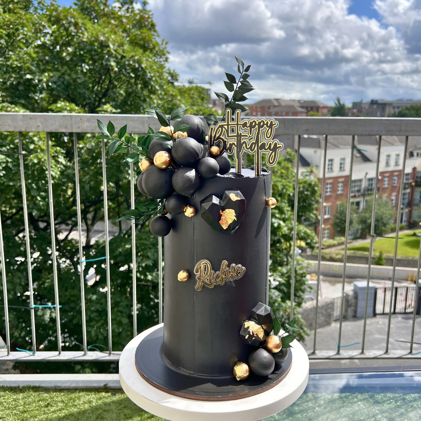 gold and black cake with gold and black balls