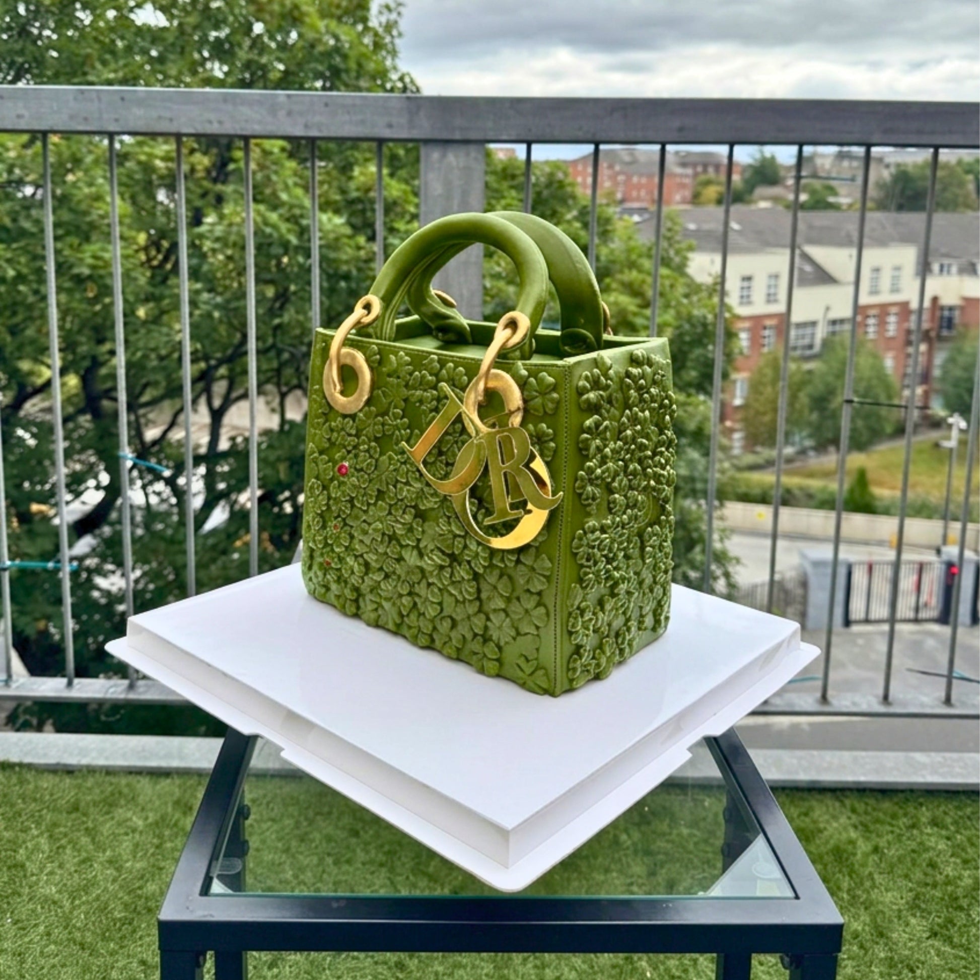 Diamond-quilted texture and rolled top handles on a black designer handbag cake