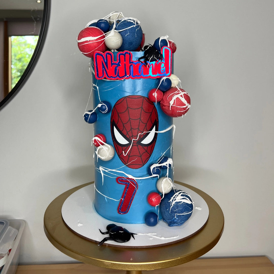 Custom superhero themed children's cake featuring red velvet sponge and comic book graphics.